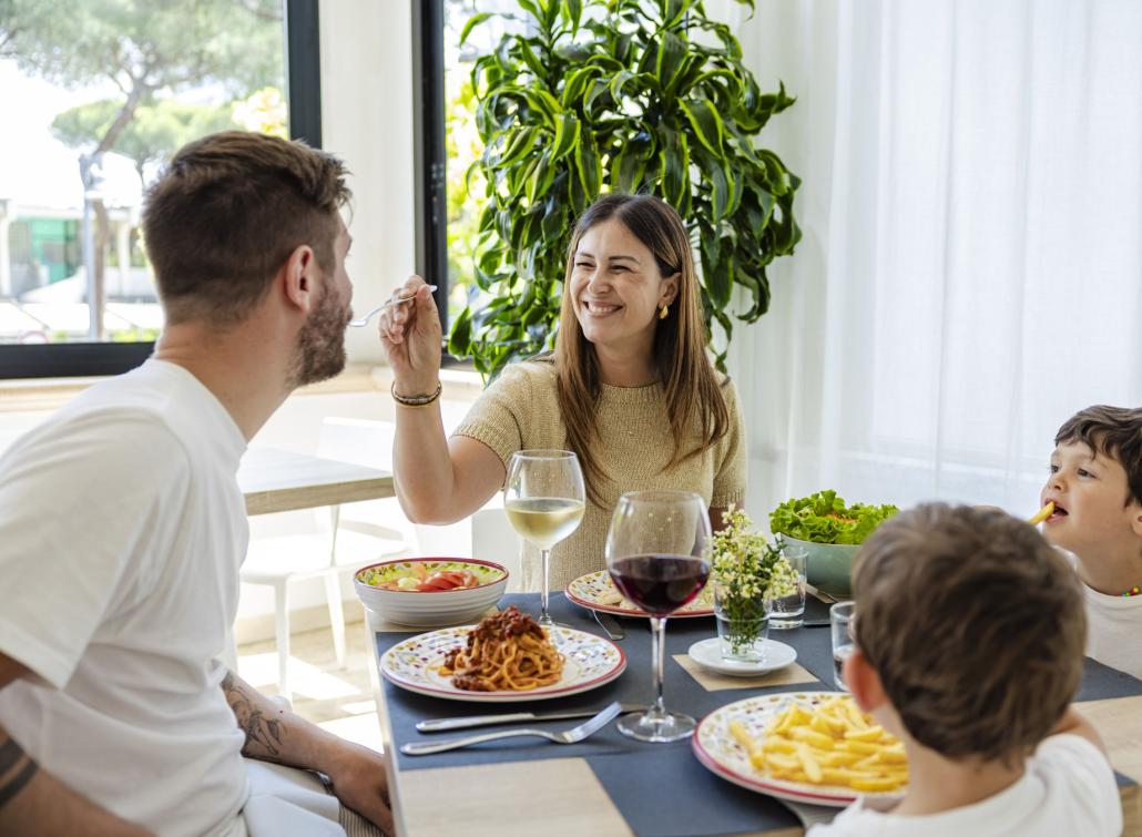 Happy family shares a meal, smiles and love fill the bright room.