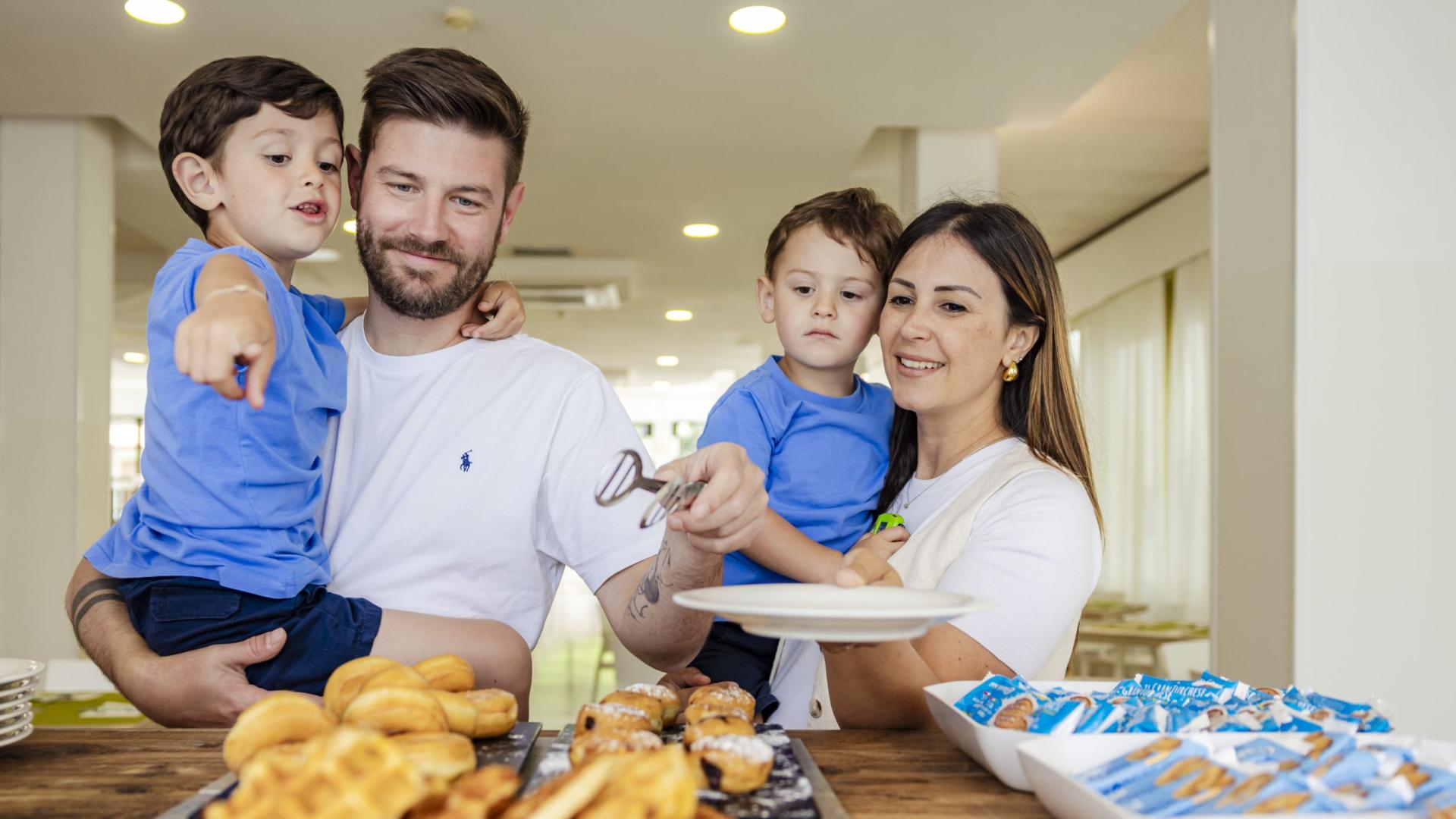 Famiglia felice sceglie dolci insieme, sorrisi e gioia condivisa.