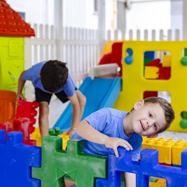 Bambini felici giocano con costruzioni colorate in un vivace parco giochi.